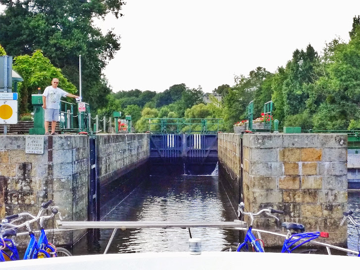 Entering one of the narrow locks with the lock keeper guiding us...in French.