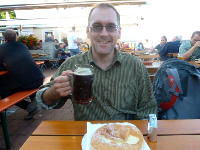 My friend enjoying a pint of the famous Andechser Doppelbock Dunkel and a Bavarian donut.