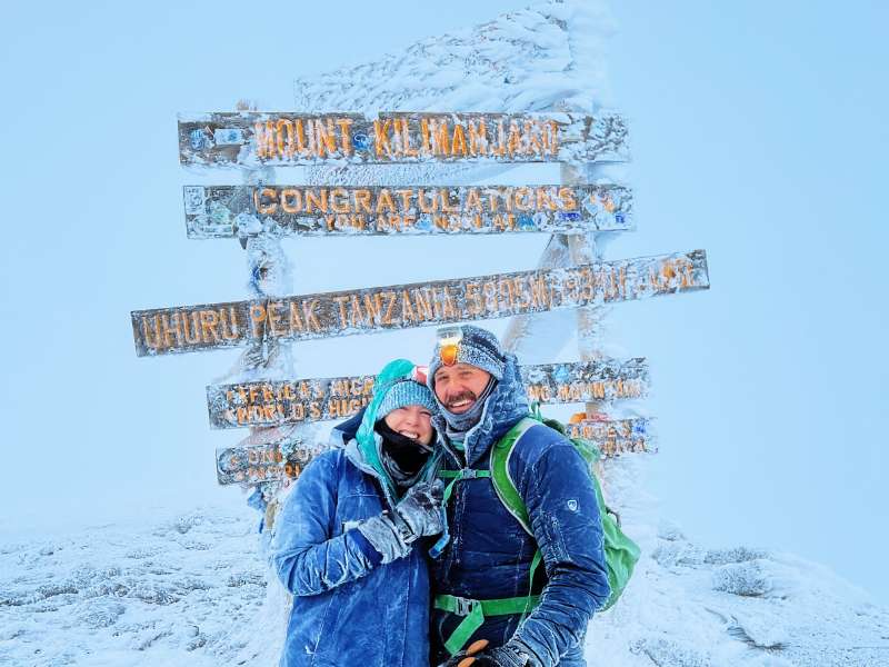 hikers at the uhuru peak in a chilly weather of the kilimanjaro tour