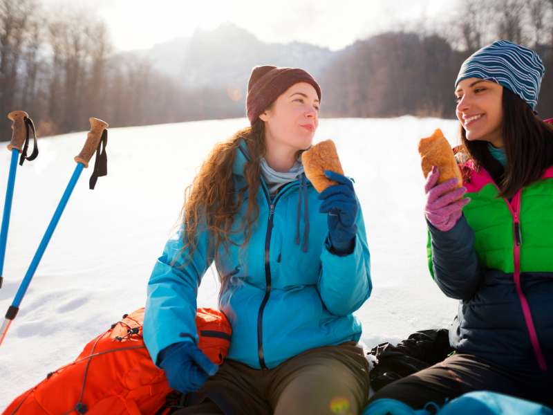 women eating lunch during a winter hike