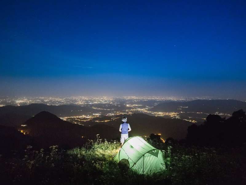 hiker at the top of a mountain at night