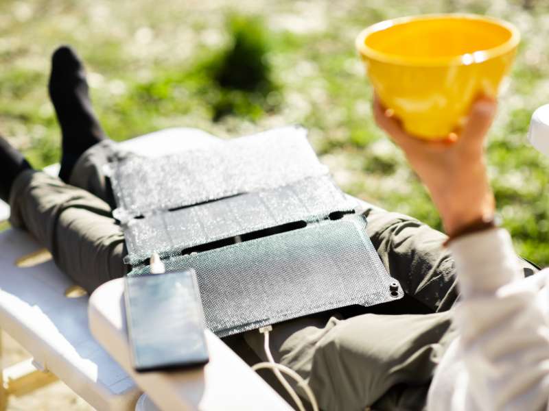 hiker with phone charging from a solar power