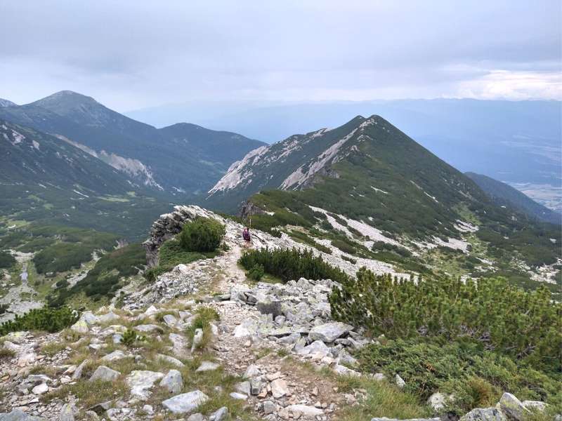 hikers climbing up together to the mountain peak