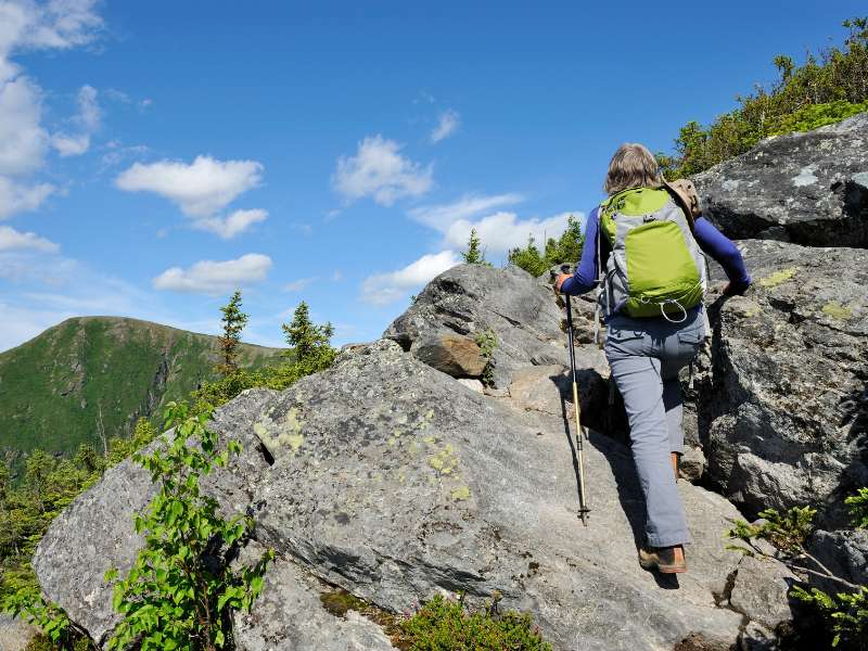 hiker climbing up a rocky mountain