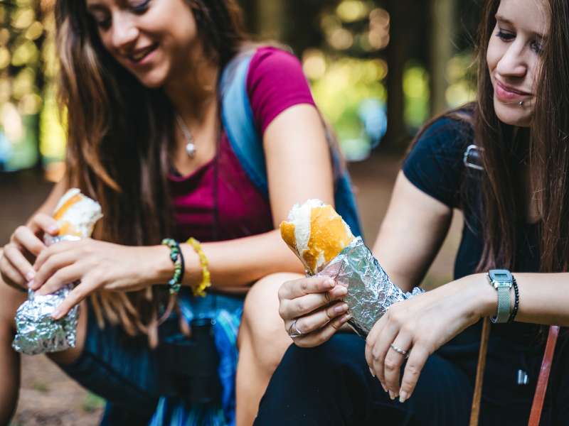 friends taking a break during hike to eat lunch