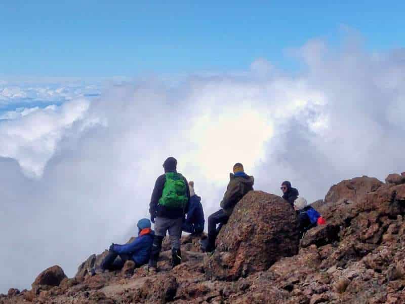 hikers at the top of mount kilimanjaro