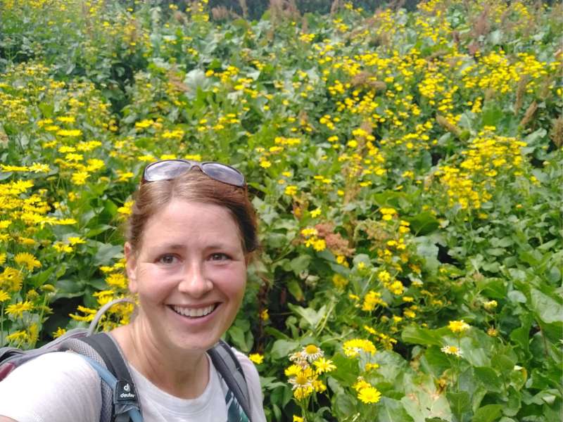 Laurel beim Wandern auf einem Pfad voller Wildblumen