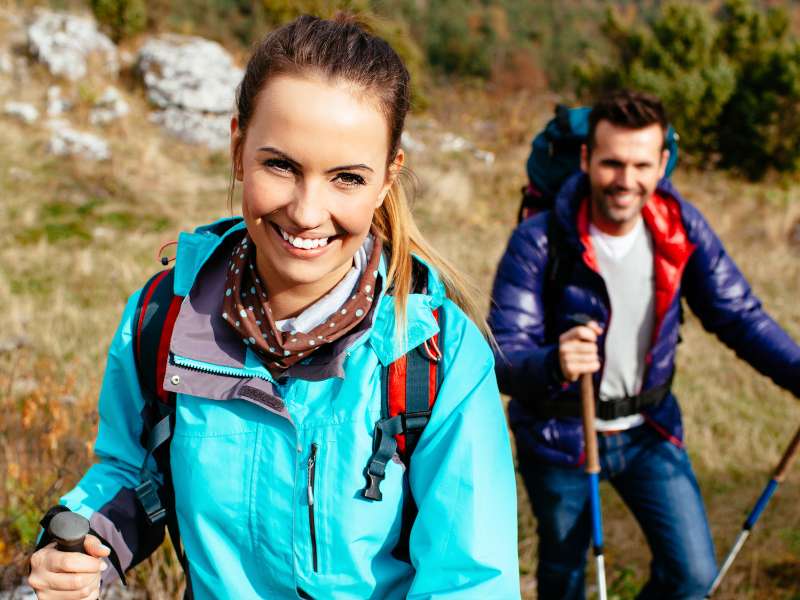 couple on a hiking date in the mountains with the woman wearing minimal outdoor and hiking makeup looking naturally beautiful