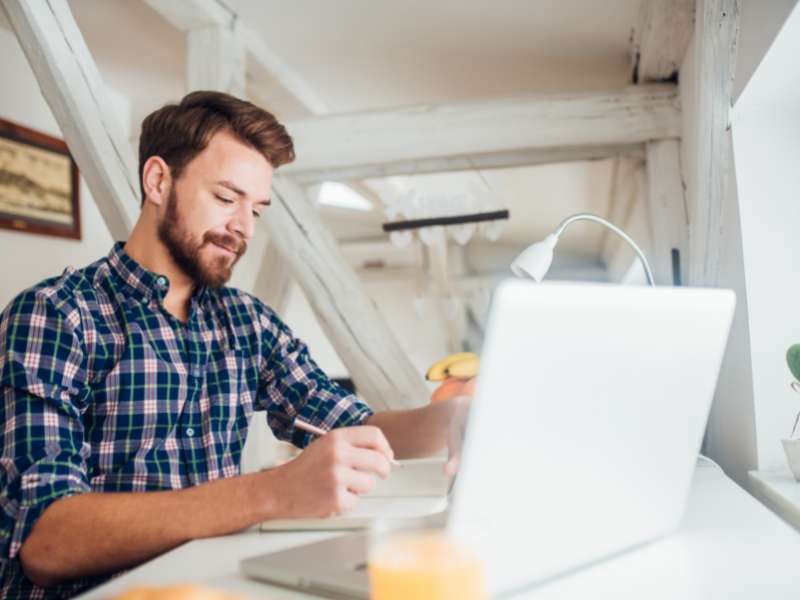 man writing on his gratitude journal