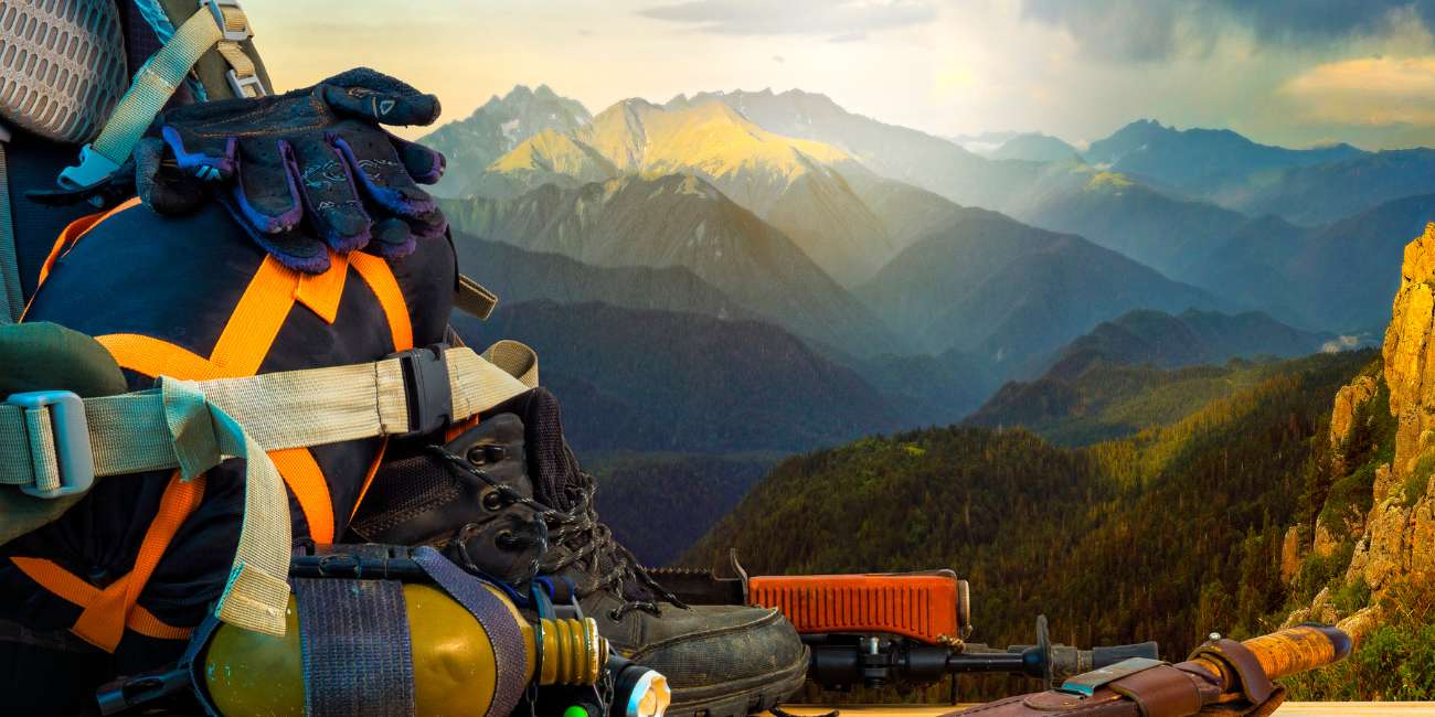 backpack with hiking gear and tools with mountains in the background