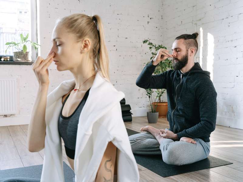 man and woman doing nostril breathwork at home