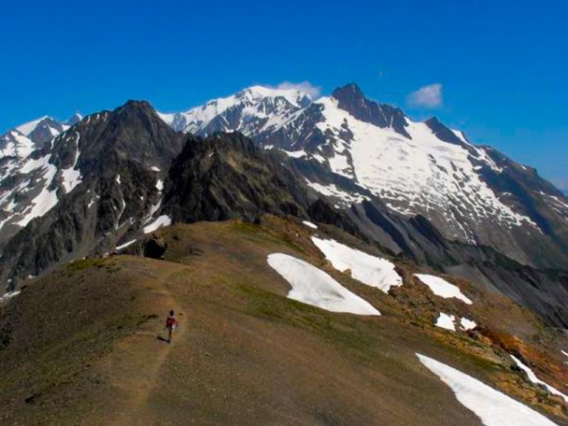 a hiker on one of the two highest points of the Tour du Mont Blanc