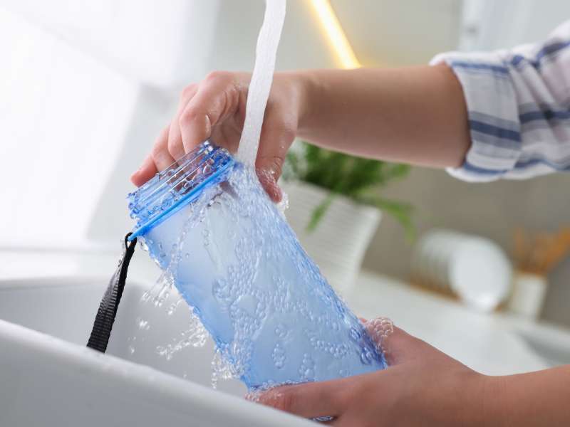 woman washing a thermal water bottle