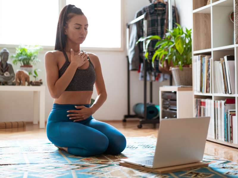 woman watching breathwork training videos at home