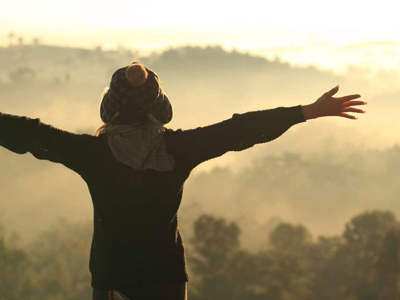 woman at the top of the mountain, enjoying nature