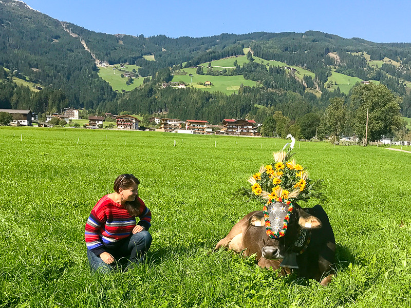 Adventure travel blogger Laurel Robbins and a decorated cow for the Almabtrieb.